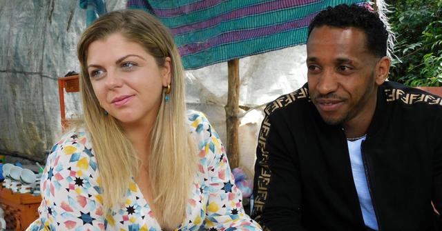 Ari Weinberg smirks next to Biniyam Shibre in an episode of '90 Day Fiancé: The Other Way'.