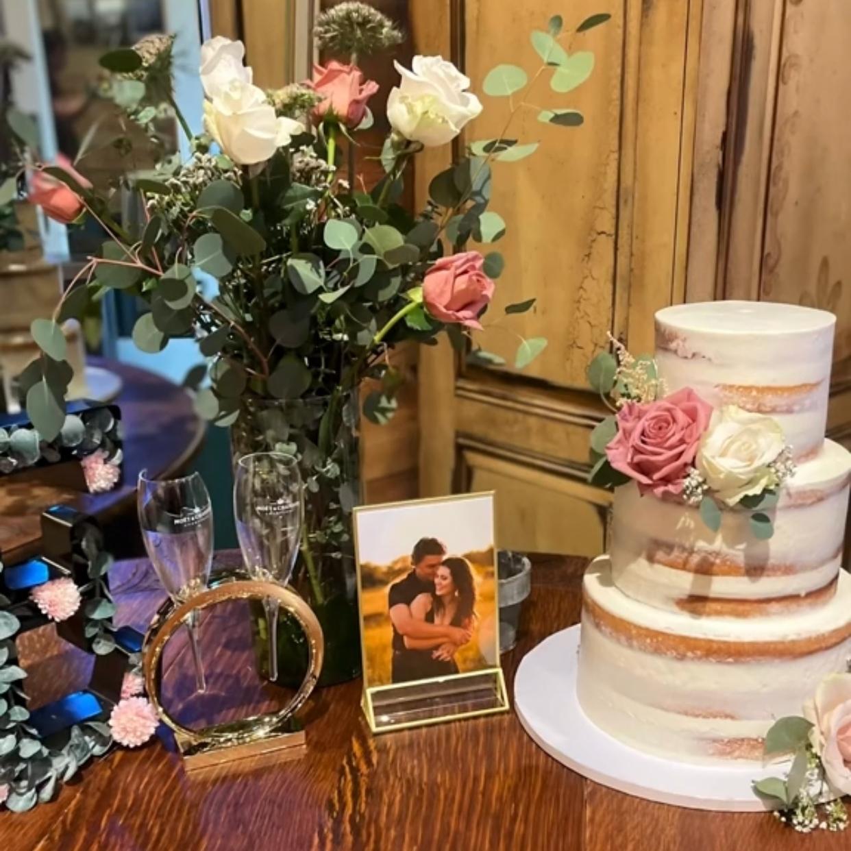 wedding cake table with flowers and champagne glasses