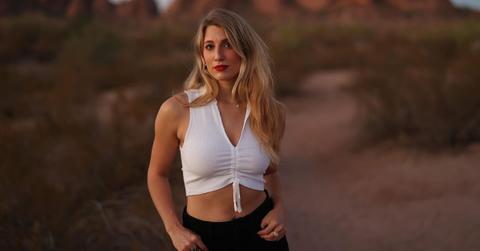 Olivia Plath in a white shirt standing in the desert