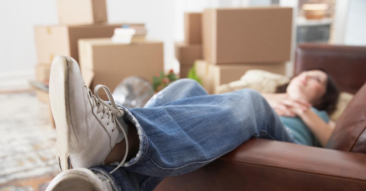 woman relaxing on couch while moving into new home