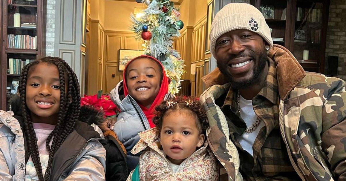 Freddie Gibbs smiling in a group photo with his three children.