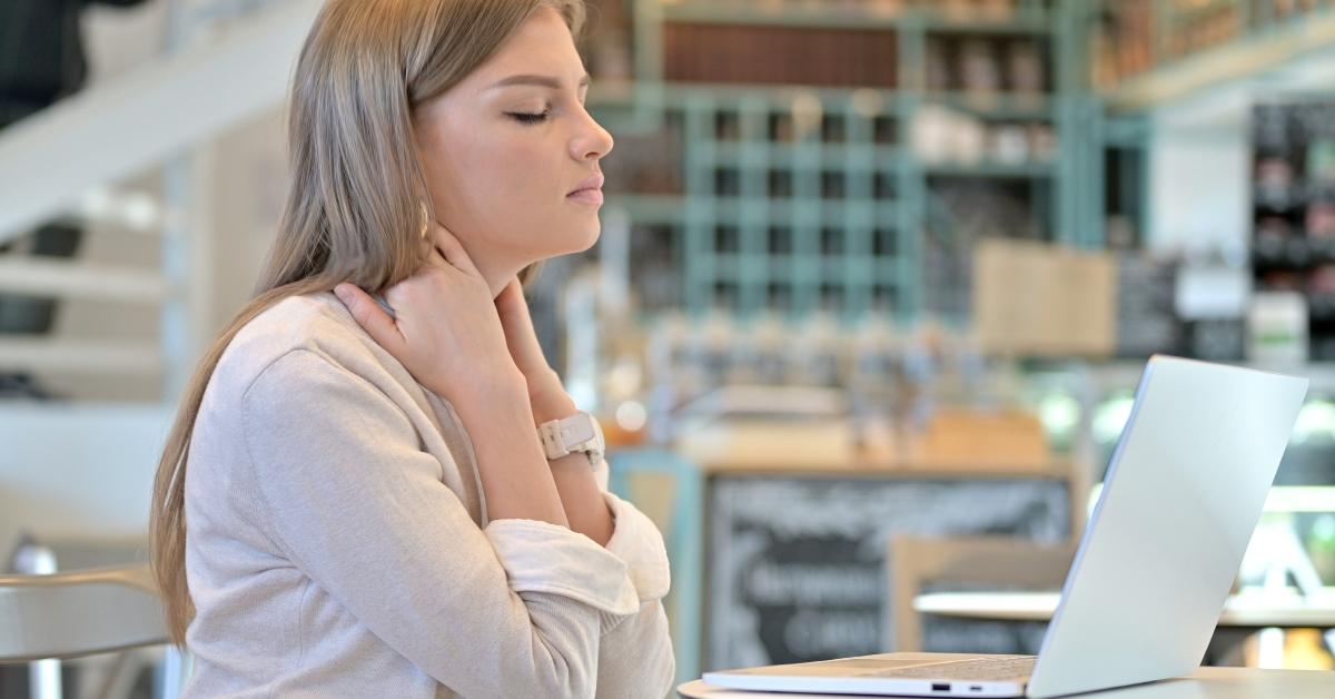 woman on laptop with a stiff neck