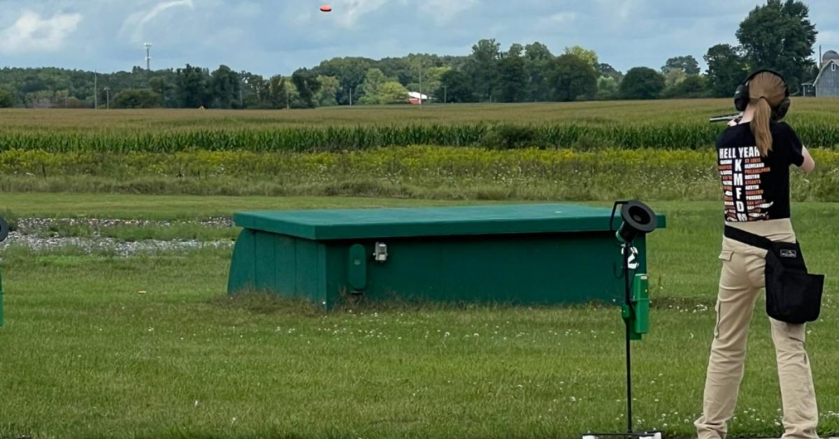 Natalie Rupnow skeet shooting while wearing a KMFDM t-shirt