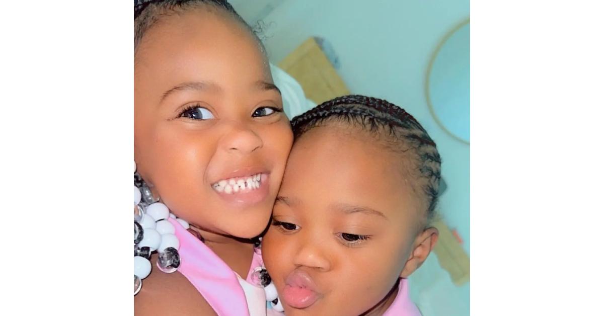 Rod Wave's daughters Mocha and Kash wearing braids and pink shirts hold each other and smile.