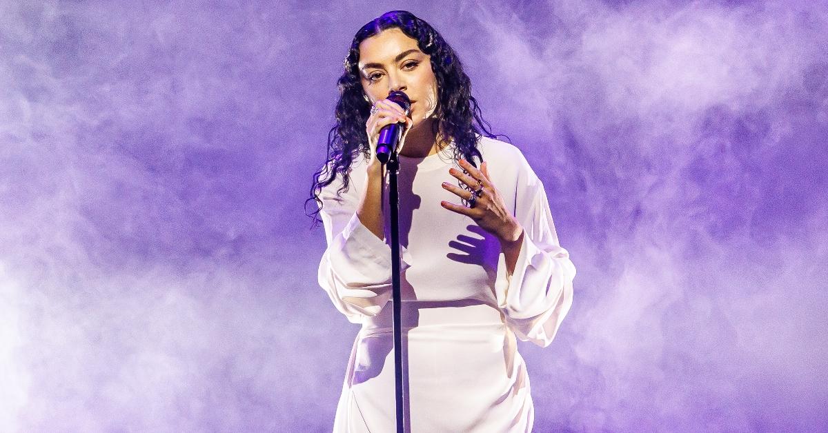 Charli XCX performs in white dress against purple background at Billboard Women in Music: Charli XCX at Billboard Women In Music 2024 held at YouTube Theater on March 6, 2024 in Inglewood, California. (Photo by Rich Polk/Billboard via Getty Images)