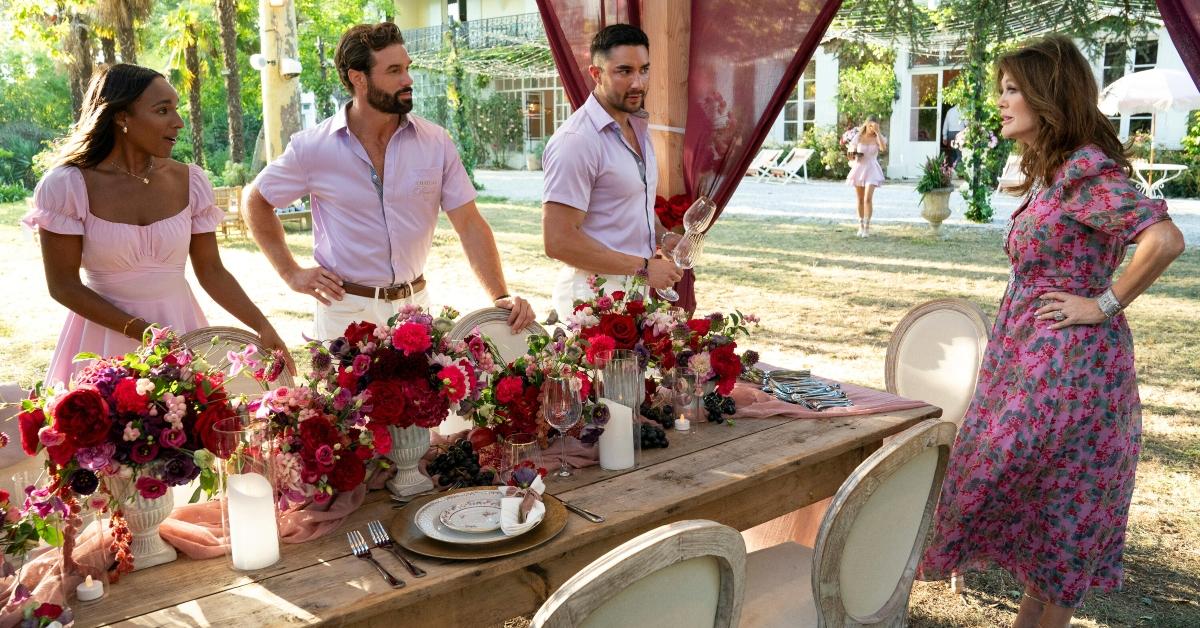 Hannah, Eric, and Marciano set a table in front of Lisa on Vanderpump Villa