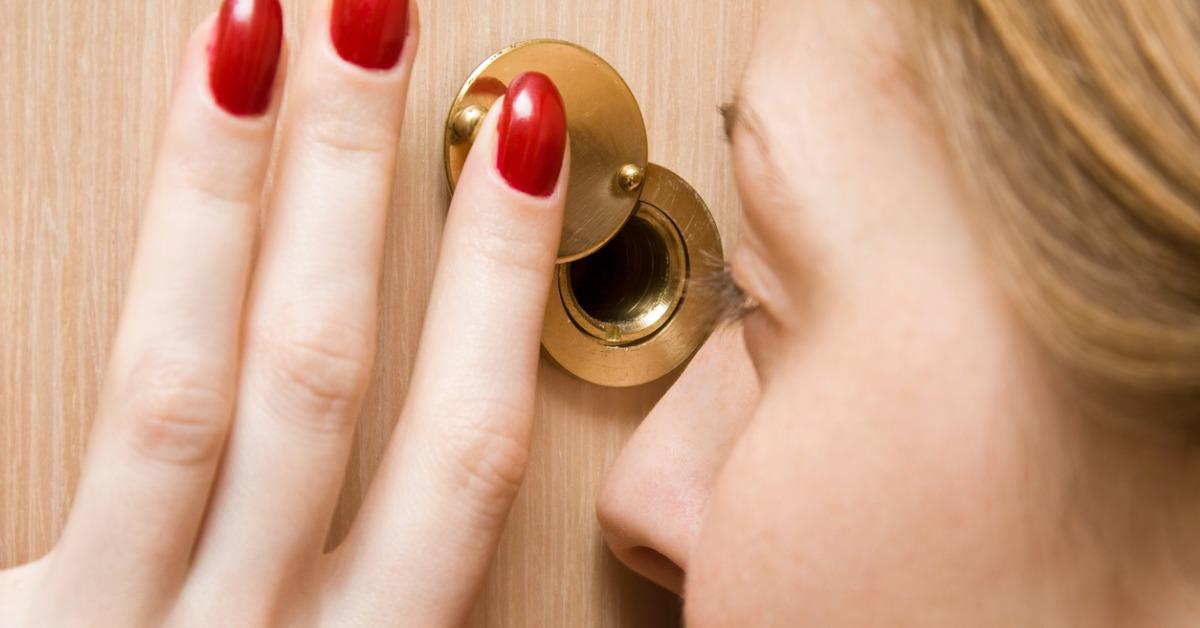 woman looking into spy hole closeup picture id