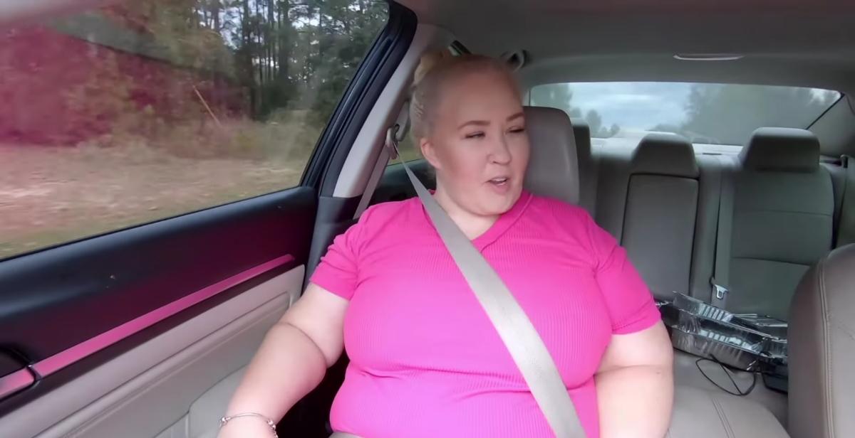 Maman June dans sa voiture en chemise rose