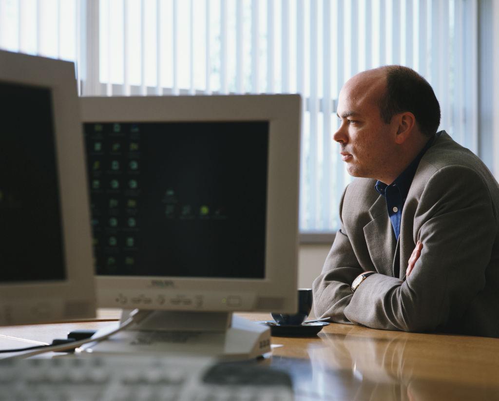 Mike Lynch sitting in front of old school computers