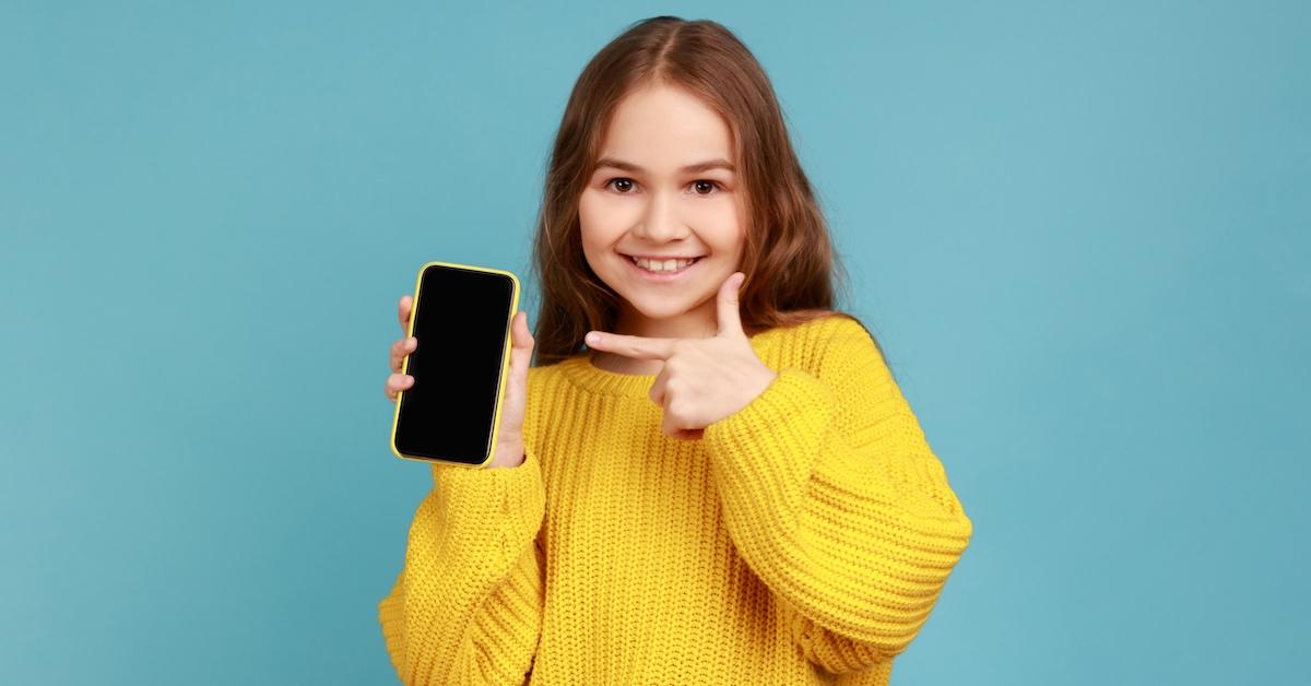 A young girl holding a cell phone