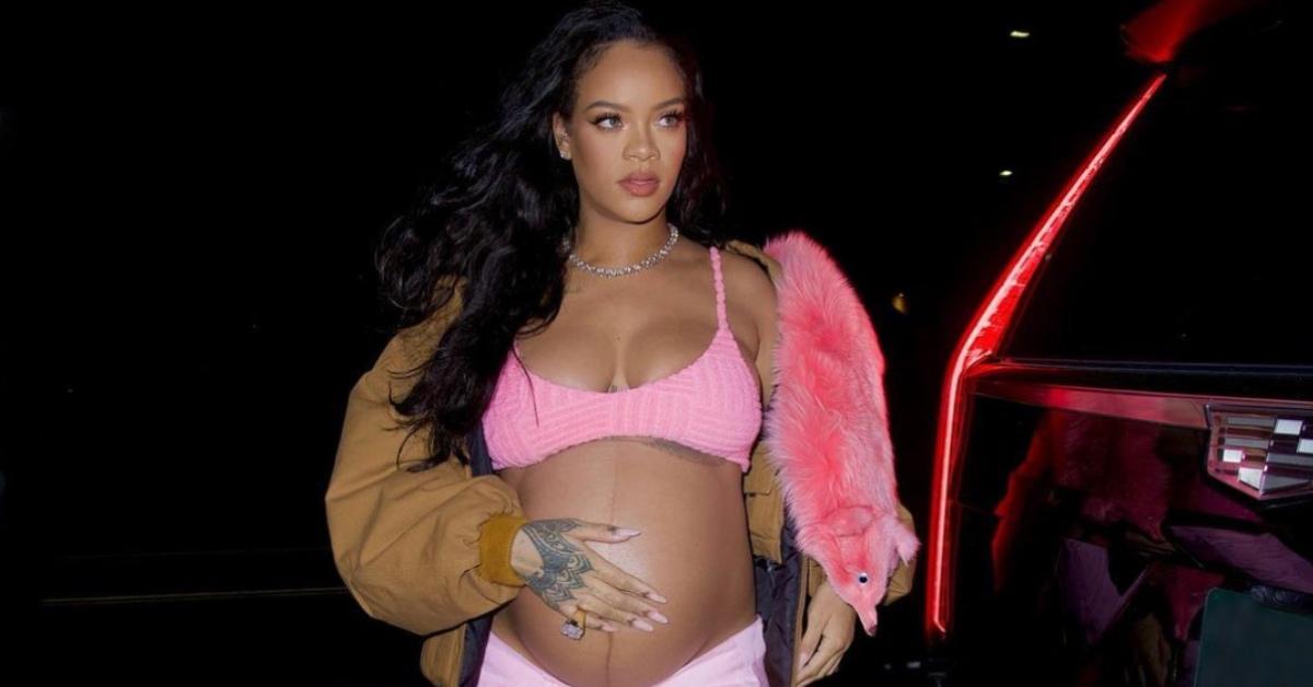 A pregnant Rihanna wearing a pink bra and bottoms.