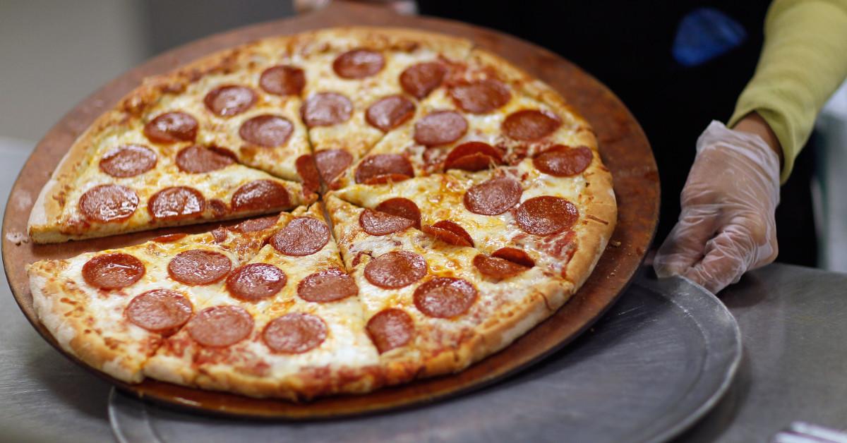 A cook preparing a pizza pie