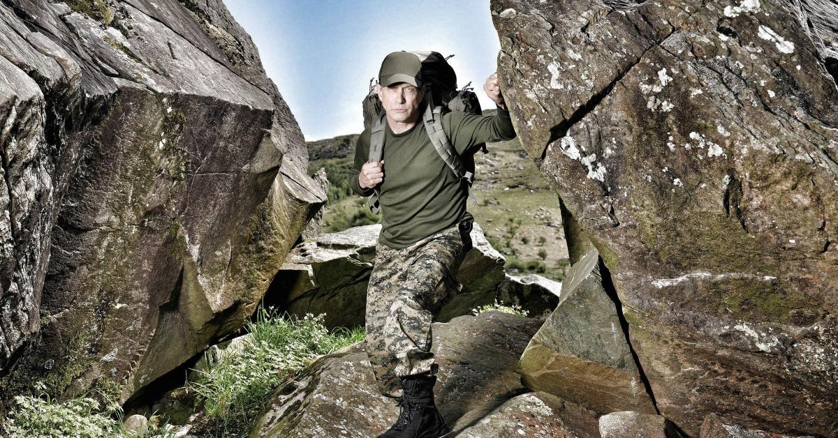 Stephen Baldwin in camo standing against some rocks