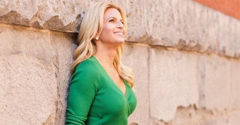 Alison Maloni leaning against a wall in a green dress.