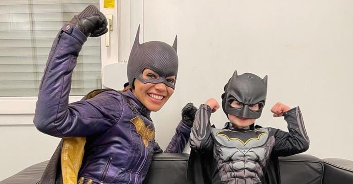 Leslie Grace in 'Batgirl' costume posing with a tiny fan.