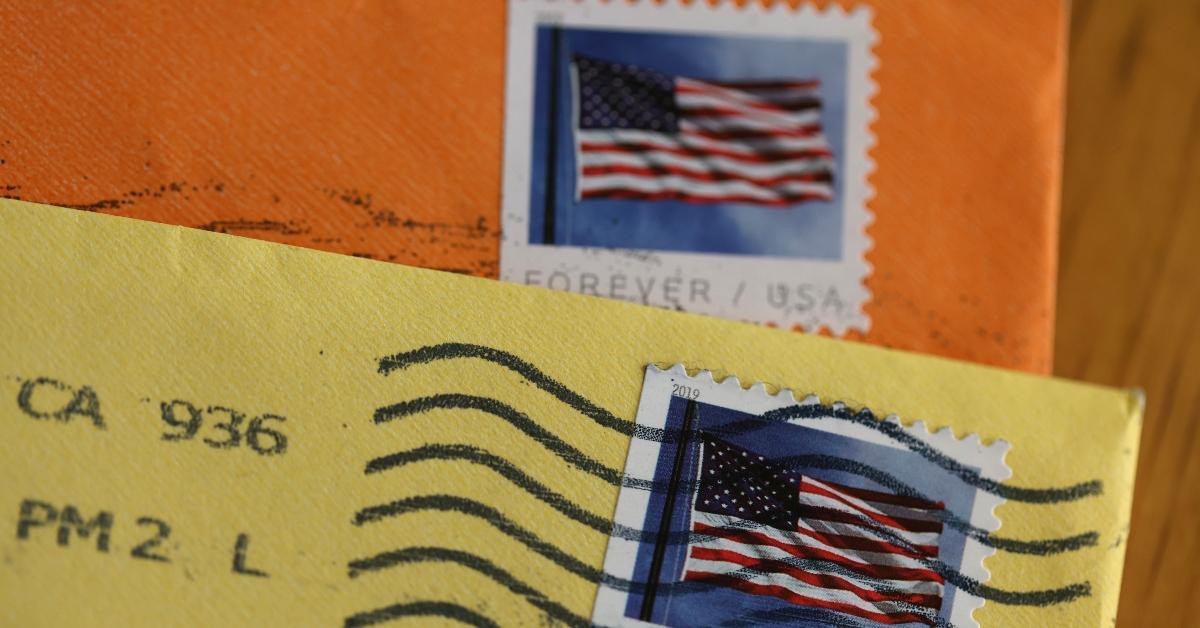 USPS Postal stamps on yellow and orange envelopes/