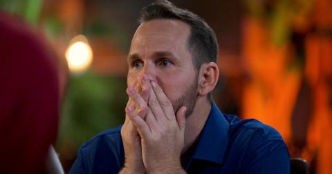 Sean acts shocked in Season 2 of 'The Mole,' covering the lower half of his face with his hands.