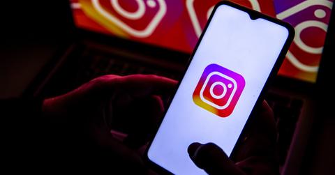 Instagram logo on a phone in the dark.