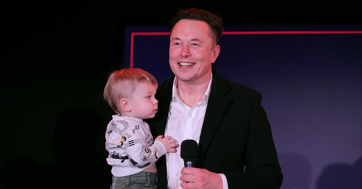 Elon Musk with his son and a microphone at a TIME Person of the Year event. 
