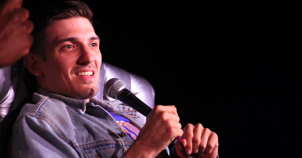 Comedian Andrew Schulz speaks into microphone