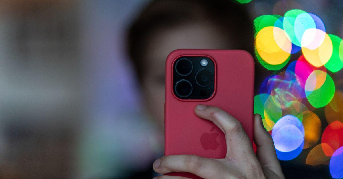 A blurred background of a child holding an iPhone which is in the foreground