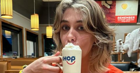 OnlyJayUs at an IHOP with a coffee cup over her mouth.