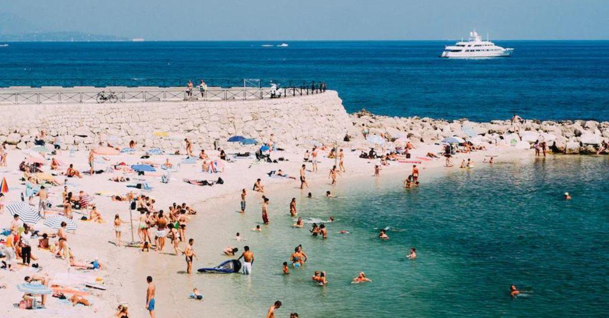 crowded beach full of people swimming