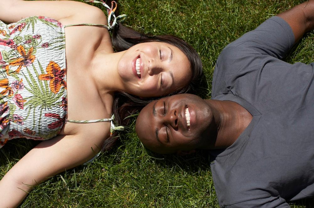 A couple laying in the grass together