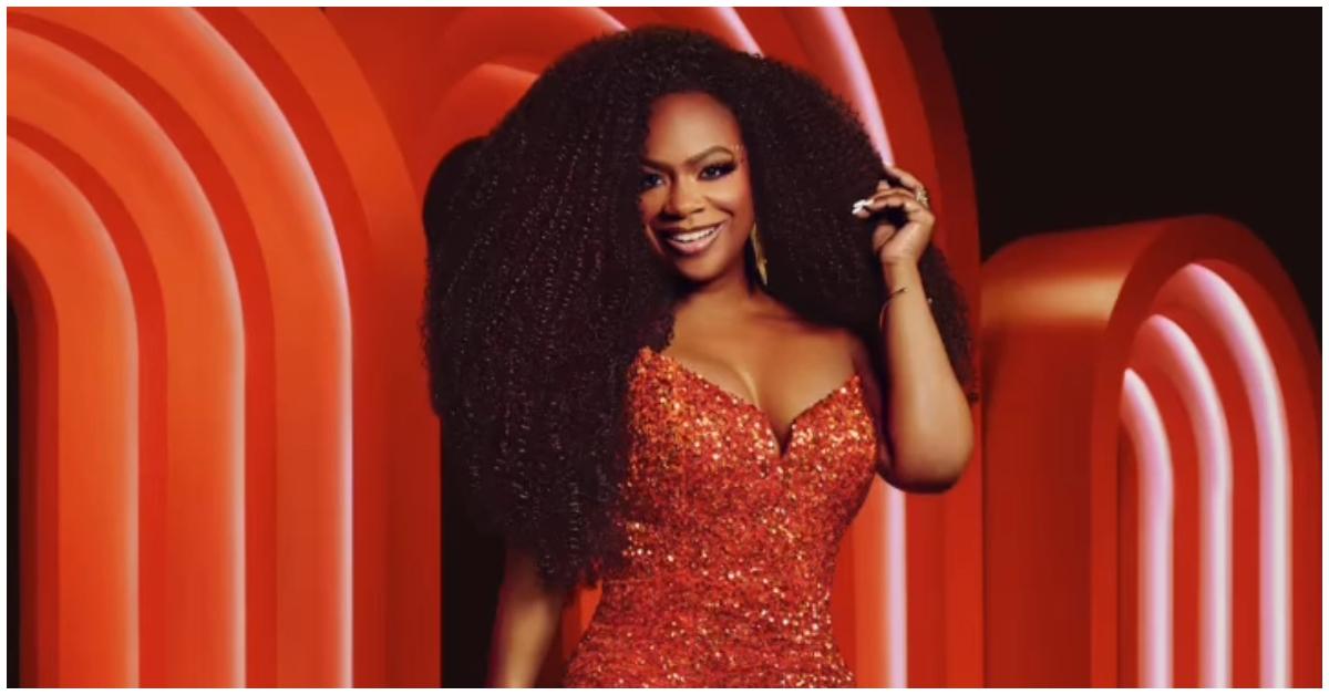 Kandi Burruss posing in a red sequined dress and curly hair