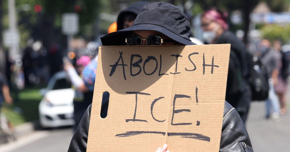 A protester holding an Abolish ICE sign.