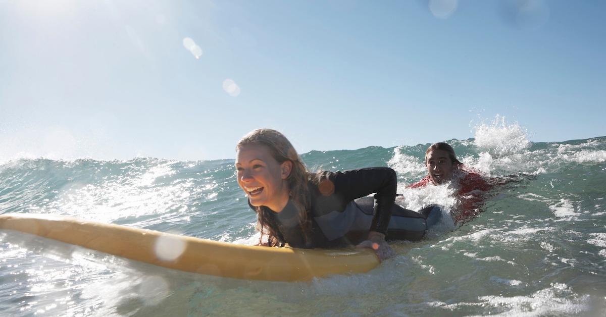 A woman and a man surfing