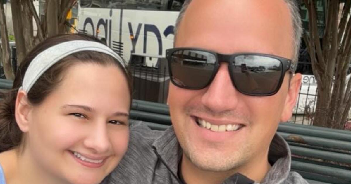 Gypsy Rose Blanchard wearing a headband and Ken Urker wearing sunglasses, sitting together outside on a bench taking a selfie