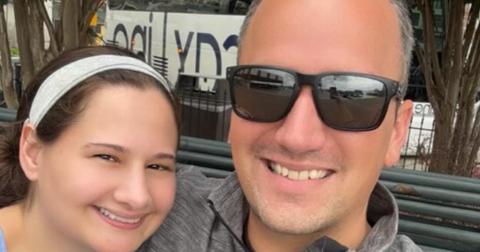 Gypsy Rose Blanchard wearing a headband and Ken Urker wearing sunglasses, sitting together outside on a bench taking a selfie