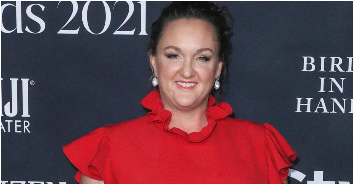 Katie Porter in a red dress posing for a press photo