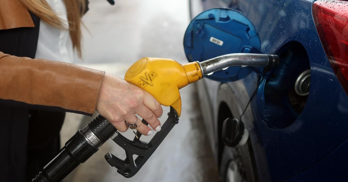 A woman holding a gas pump nozzle