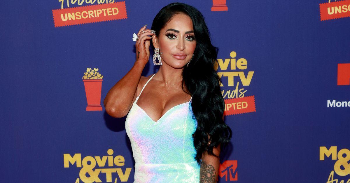 Angelina Pivarnick brushes her hair back as she poses for a photo at the MTV movie award red carpet