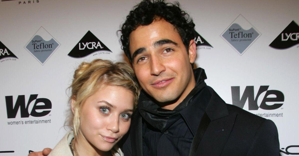 (l-r): Ashley Olsen and Zac Posen smiling together at a red carpet event.