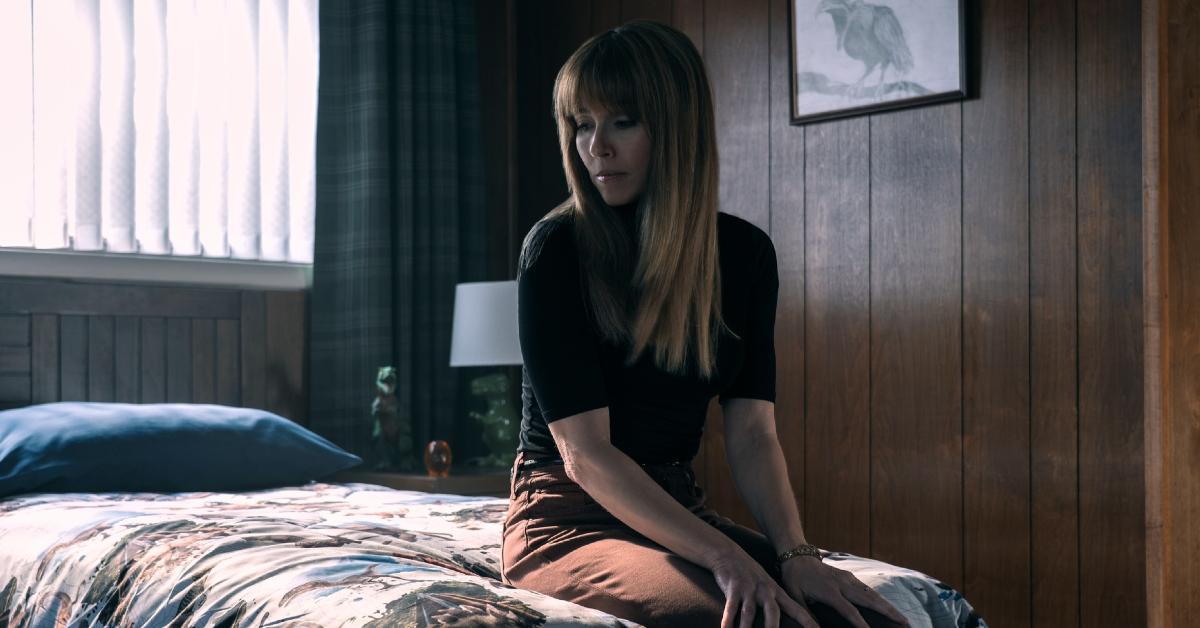 Carol sitting on a bed in 'DTF: St. Louis'.