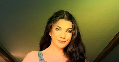 Elphaba smiling in a denim sleeveless top