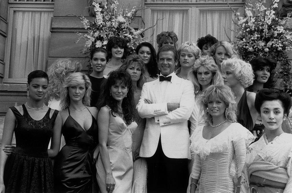 Film star Roger Moore (James Bond) and the Bond Girls from the film 'View to a Kill' directed by John Glen