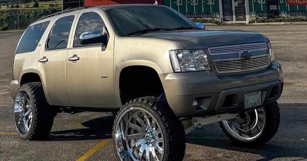 A Chevy SUV that has been converted into a squatted truck