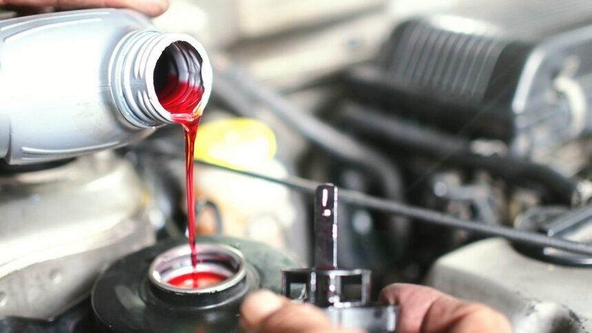 Red antifreeze being poured into a car