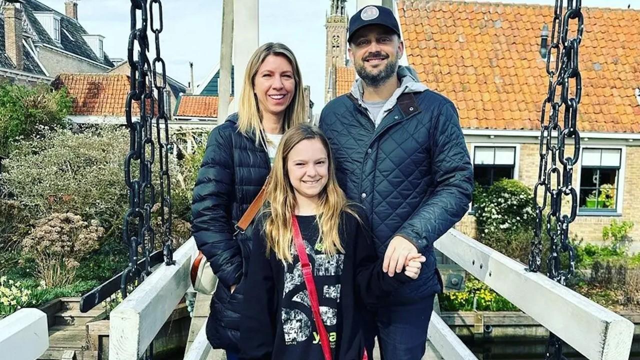 Nate, Laura, and Harper Bargatze standing near a garden