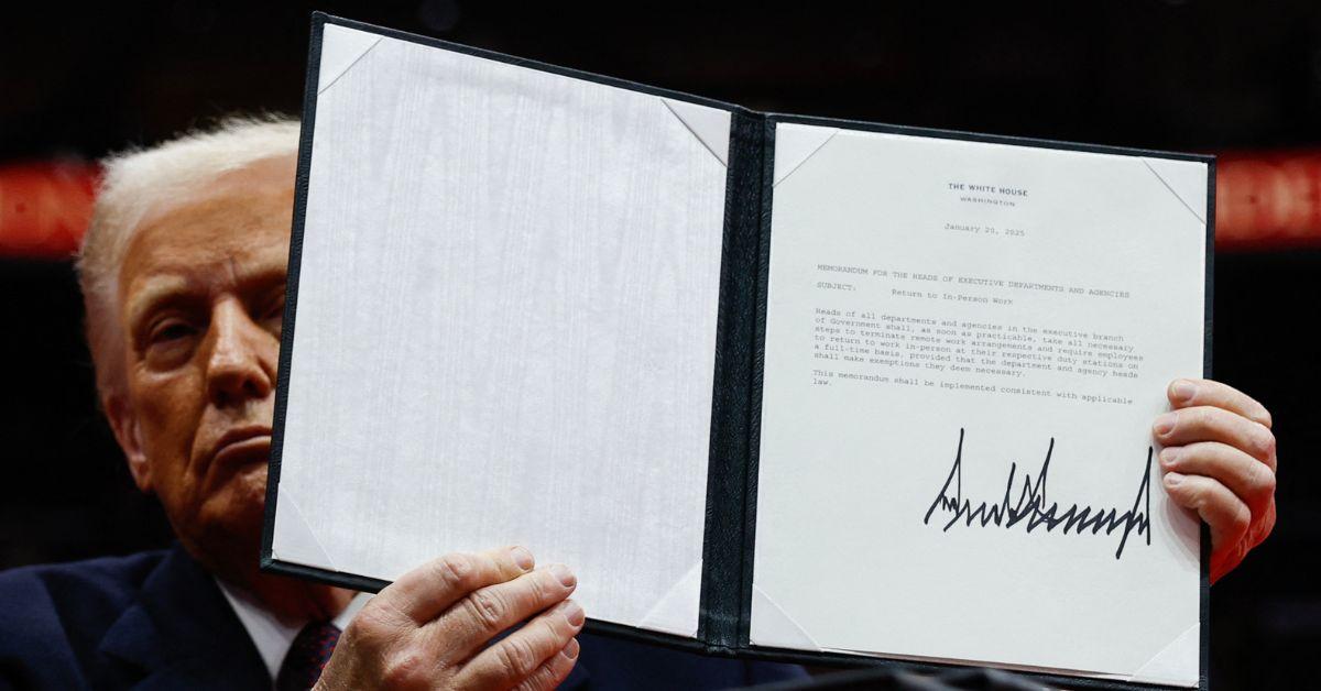 Donald Trump showing his signature on an executive order. 