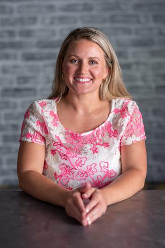 Ryan is dressed in a sheer white shirt with pink floral designs, smiling for her official portrait for Season 2 of 'The Mole.'