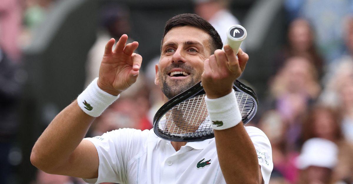 Novak Djokovic holding his tennis racket like a violin. 