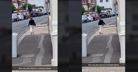 A woman appears to be frozen in the middle of a street