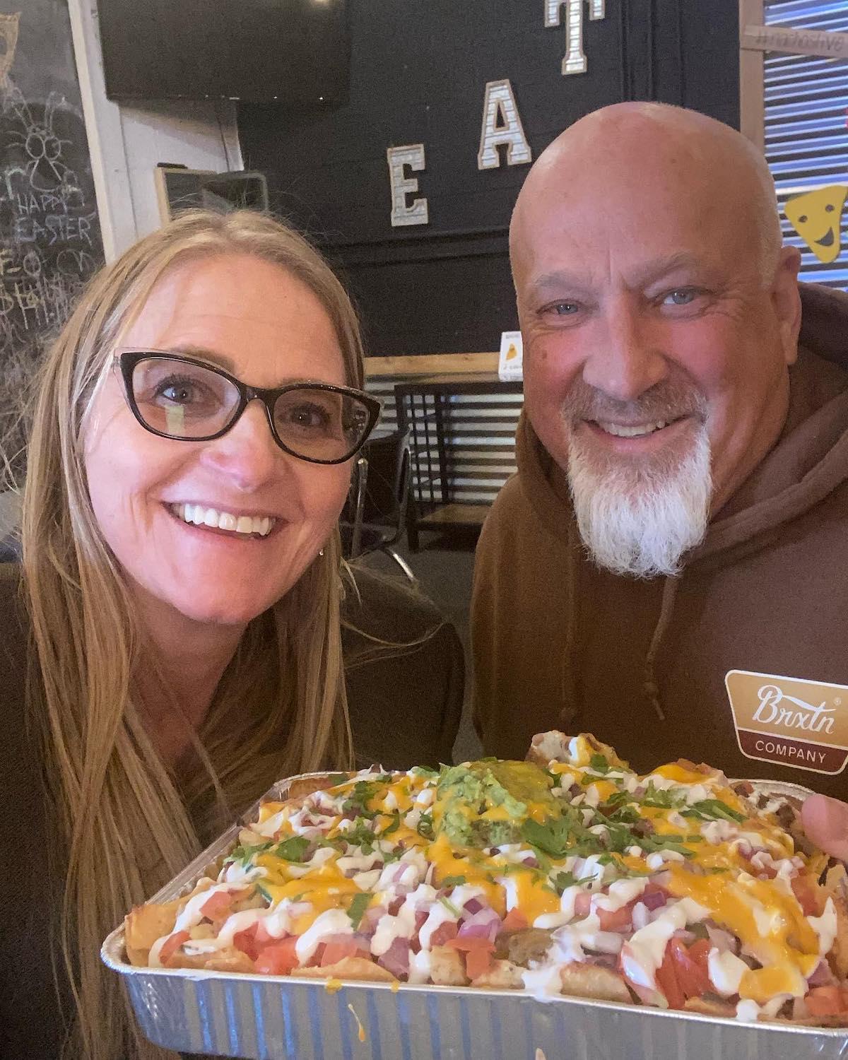 Christine Brown and David Woolley smiling with nachos