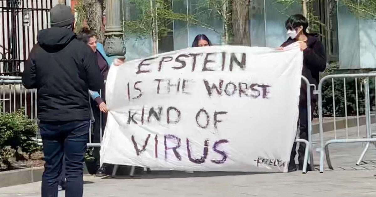 Protestors with a sign about Jeffrey Epstein