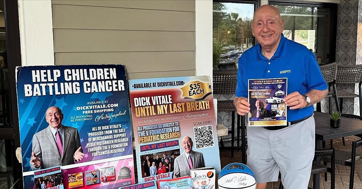 Dick Vitale poses with his book covers